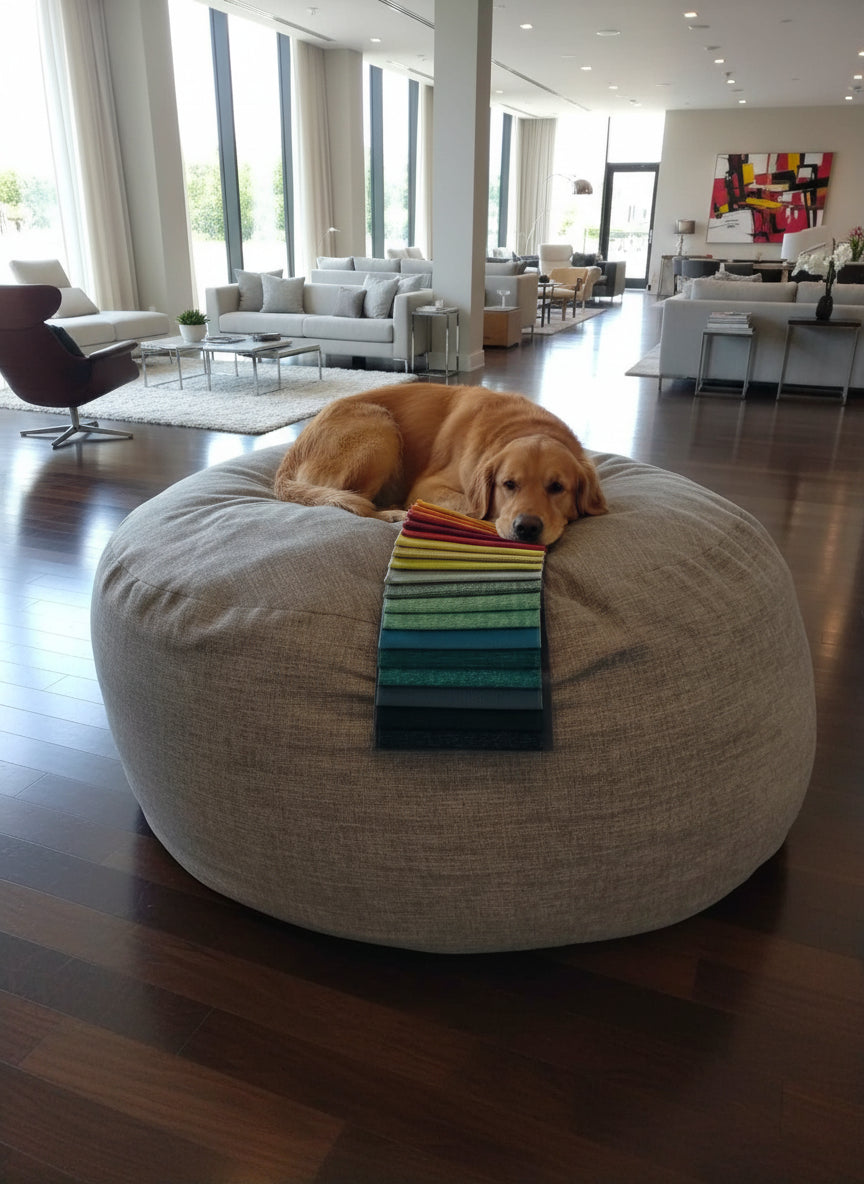 Round beige ottoman with a colorful striped cushion on top, placed indoors.