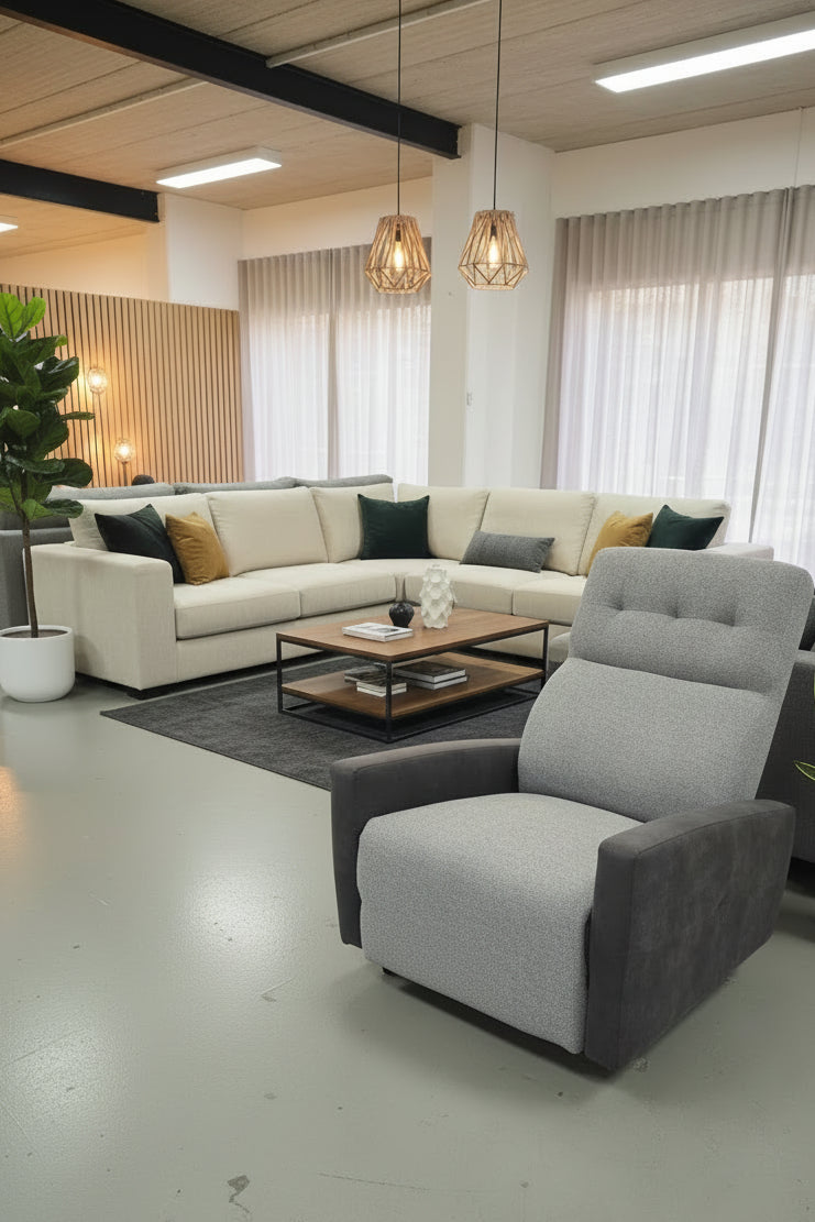 Gray recliner chair in a furniture store with other chairs and decor in the background.