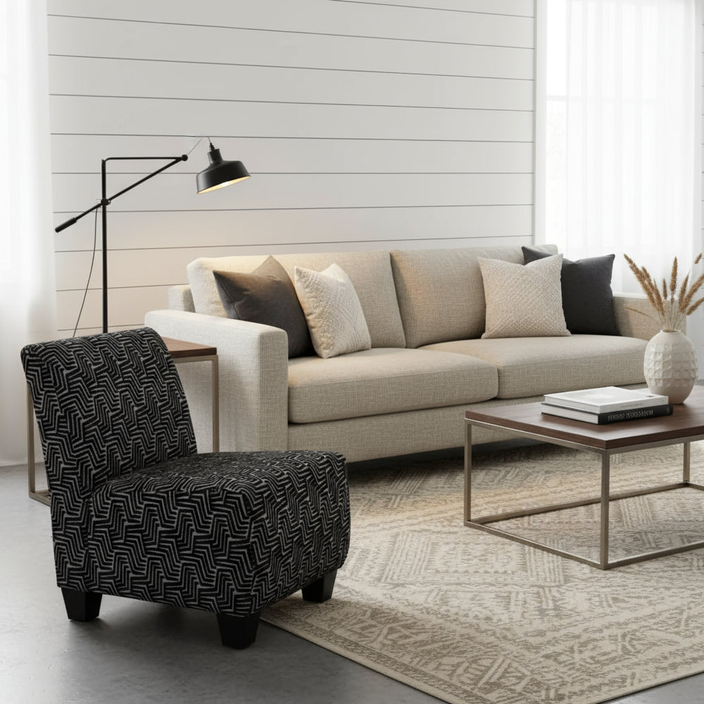 Black and white patterned chair next to a potted plant on a patterned rug.