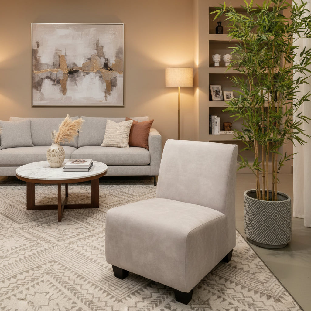 Gray upholstered chair next to a potted plant on a patterned rug.