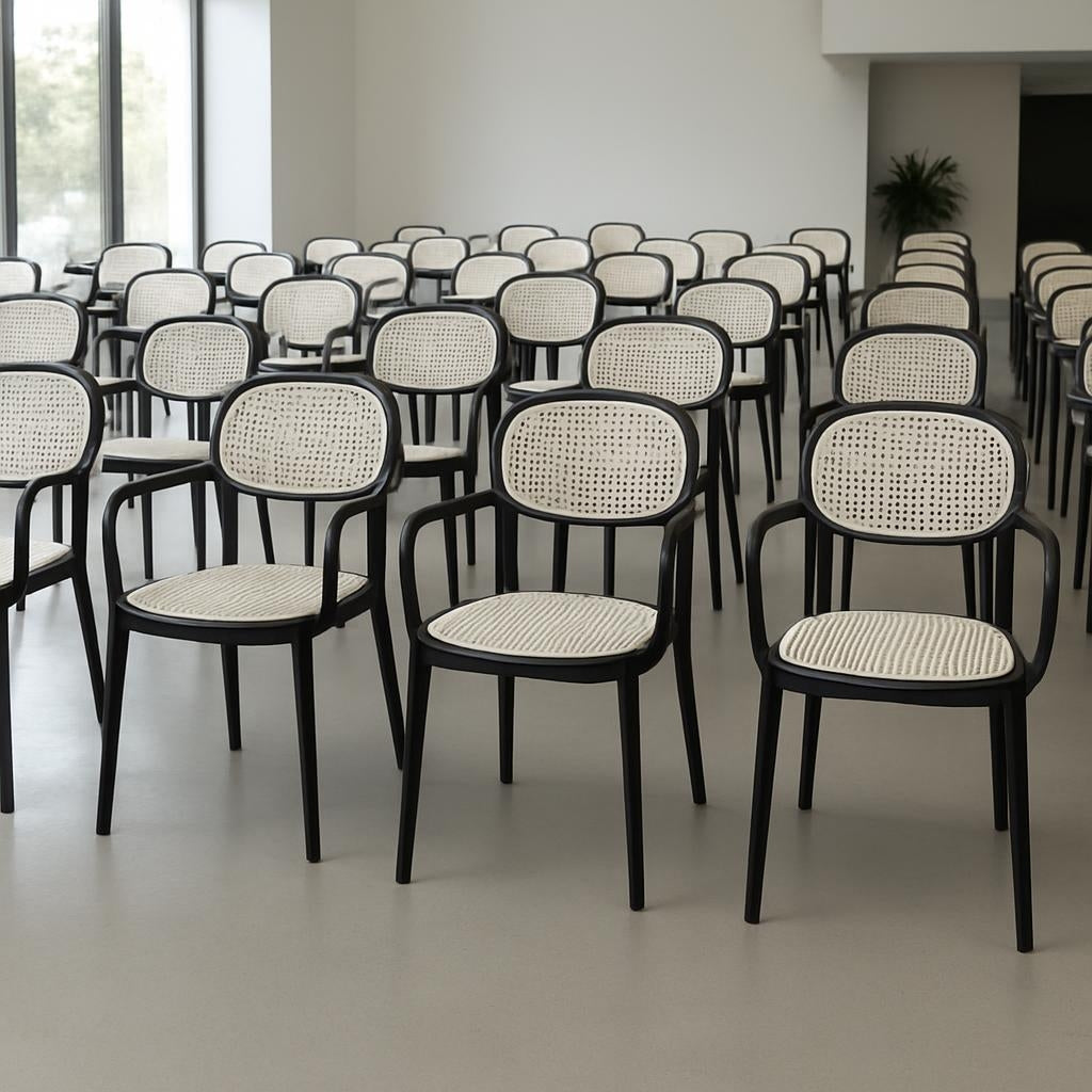 Row of black chairs with white woven seats in a room.